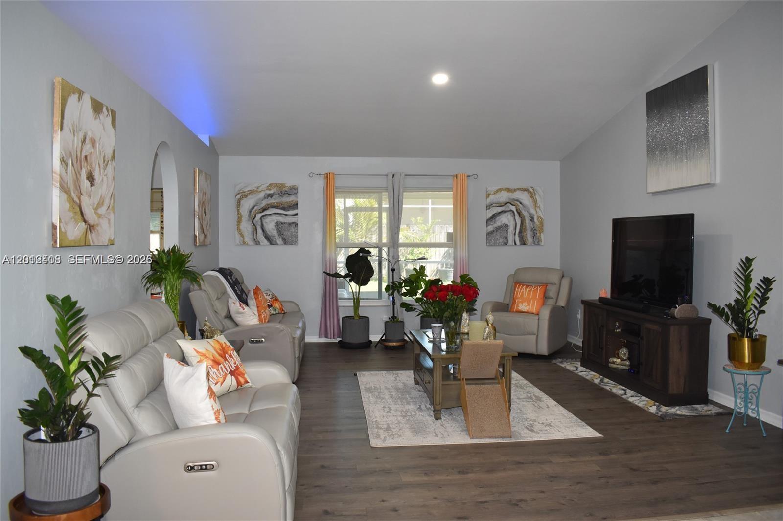 15639 Spring Line Lane Fort Myers, FL 33905 - Photo 2 of 14 a living room with furniture a flat screen tv and a potted plant