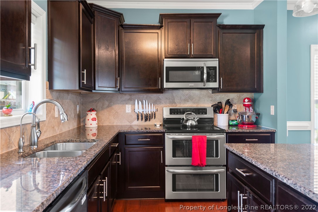 207 Samuel Nicholas Drive Cameron, NC 28326 - Photo 15 of 31 a kitchen with stainless steel appliances granite countertop a sink stove and refrigerator
