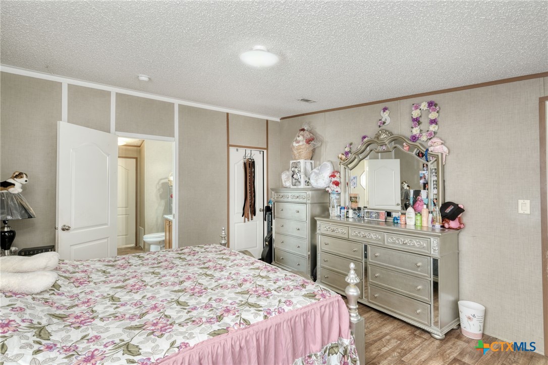 181 Pasadera Drive Elgin, TX 78621 - Photo 15 of 33 a room with a bed and a dresser in it