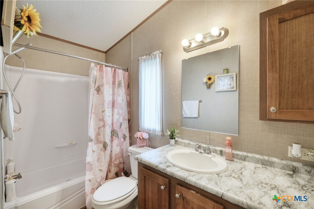 181 Pasadera Drive Elgin, TX 78621 - Photo 21 of 33 a bathroom with a granite countertop sink toilet and shower