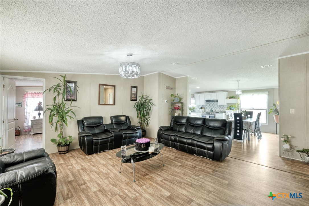181 Pasadera Drive Elgin, TX 78621 - Photo 8 of 33 a living room with furniture and a chandelier