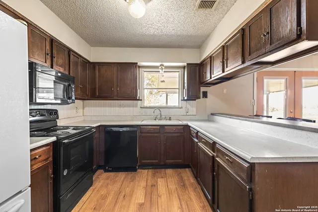 a kitchen with a sink stove and microwave