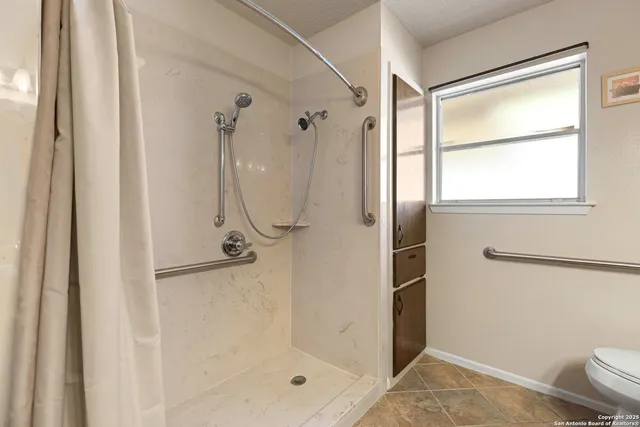 an empty room with wooden floor and ceiling fan