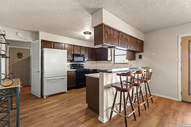 a kitchen with stainless steel appliances granite countertop a sink and wooden cabinets