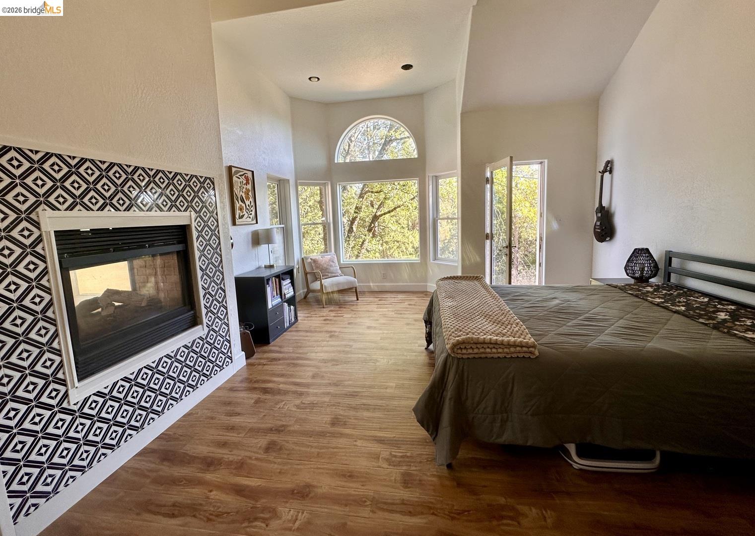 2080 Nelson Road Camino, CA 95709 - Photo 42 of 55 Vaulted ceiling, wood-finish flooring, fireplace with decorative tile surround, multiple windows, and exterior access via French doors