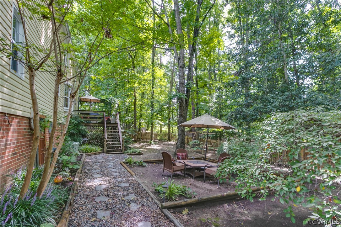 5302 Chestnut Bluff Road Midlothian, VA 23112 - Photo 8 of 50 a backyard of a house with table and chairs under an umbrella