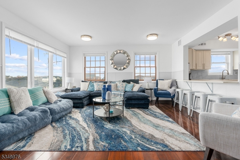 a living room with furniture wooden floor and a large window