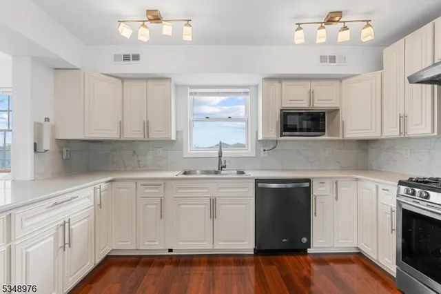 a kitchen with white cabinets appliances and sink