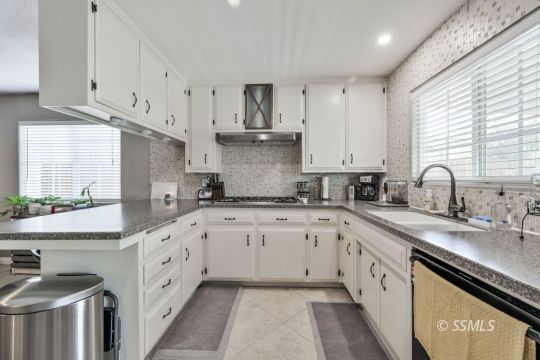 1267 North Erwin Street Ridgecrest, CA 93555 - Photo 3 of 35 a kitchen with granite countertop white cabinets white appliances sink and window