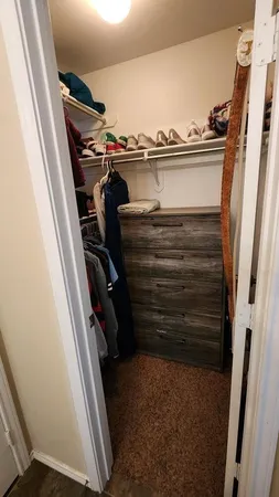 a view of walk in closet with clothes and shoes
