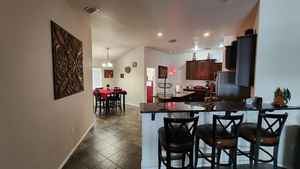 a view of a dining room with furniture and a chandelier fan