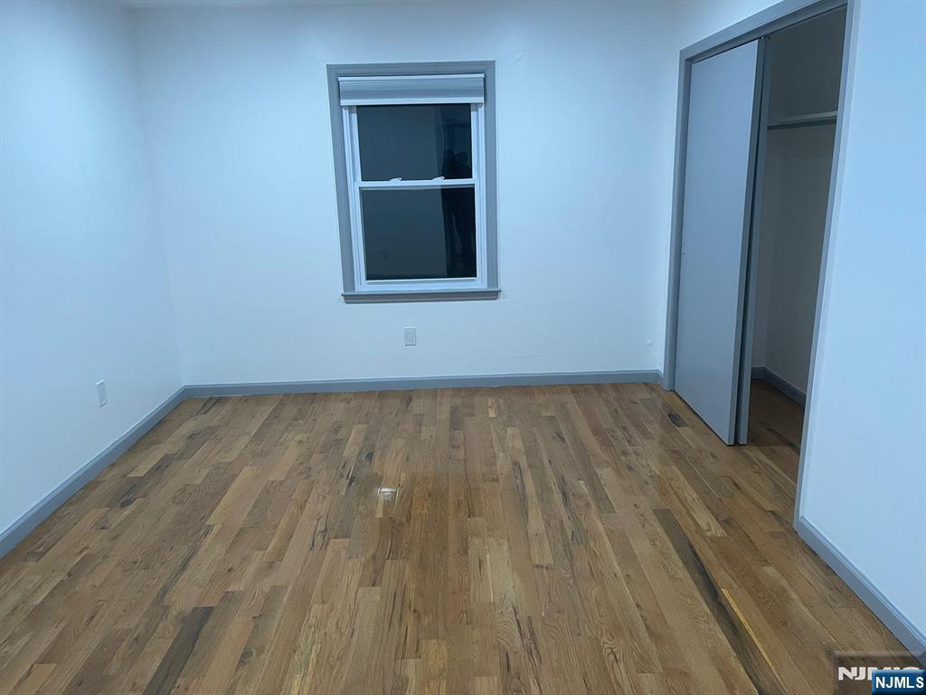 607 Nassau Street, Unit 2 Orange, NJ 07050 - Photo 5 of 10 a view of a room with wooden floor and a window