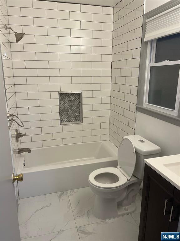 607 Nassau Street, Unit 2 Orange, NJ 07050 - Photo 9 of 10 a white toilet and tub sitting next to a bathroom sink