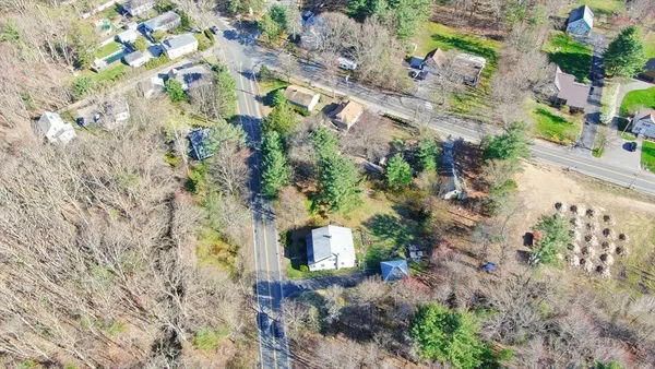 a aerial view of a house with a yard and large trees