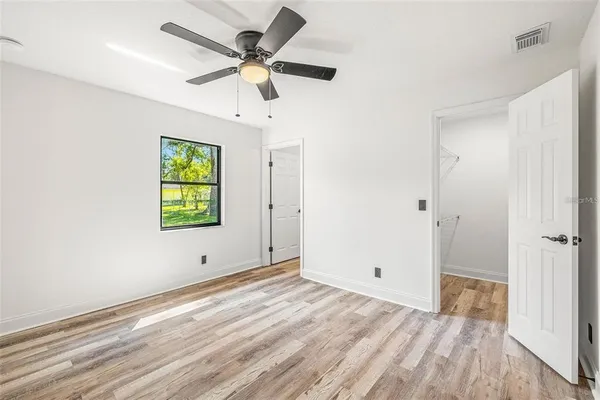 a view of room with window ceiling fan and wooden floor