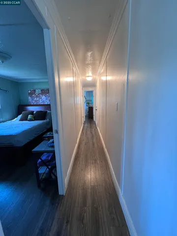 a view of a hallway with wooden floor and closet