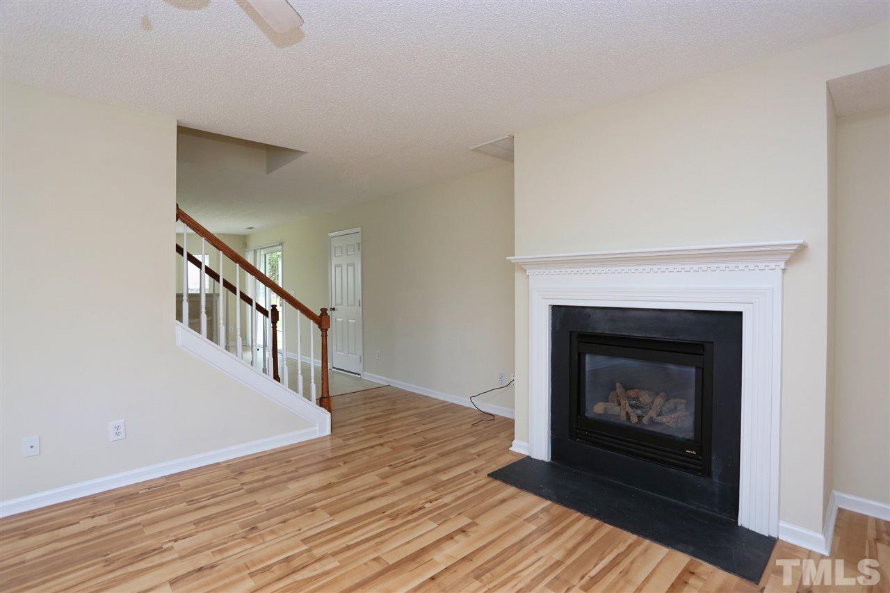 2610 Quarry Ridge Lane Raleigh, NC 27610 - Photo 5 of 23 a view of an empty room with wooden floor fireplace and a window