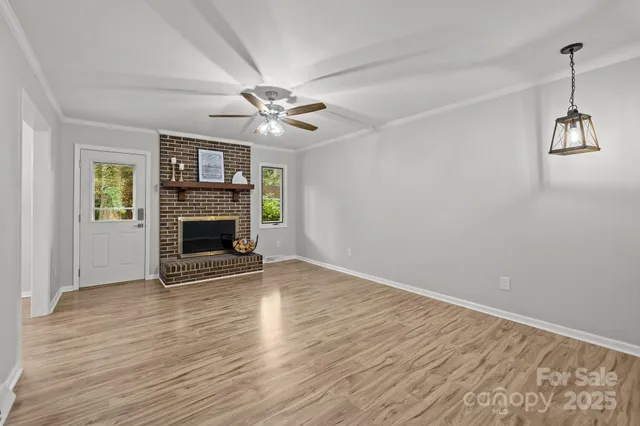 an empty room with windows fireplace and a sink