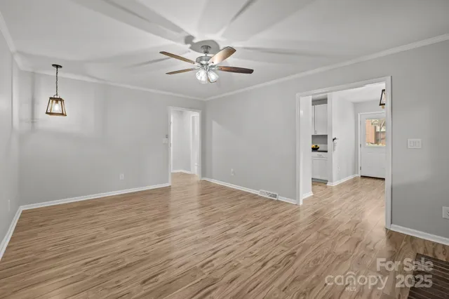 a view of an empty room with wooden floor