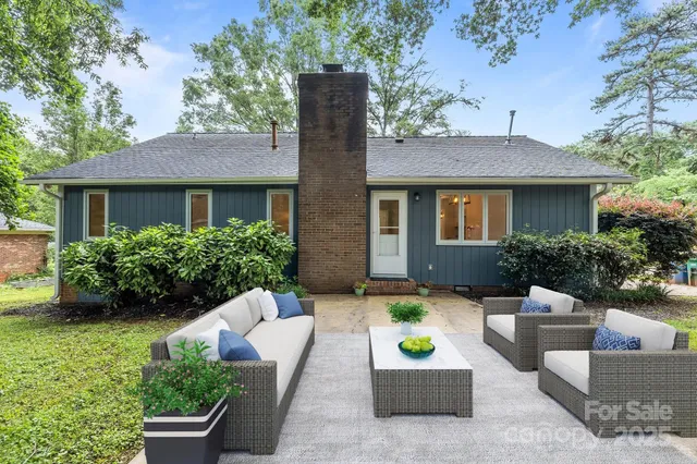 a view of a house with a yard and furniture