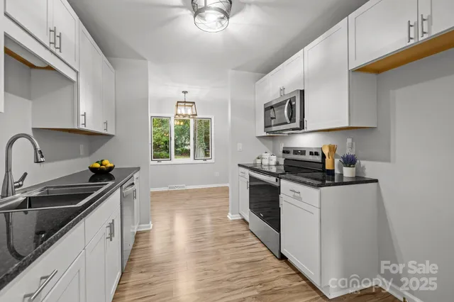 a kitchen with stainless steel appliances a sink stove and cabinets