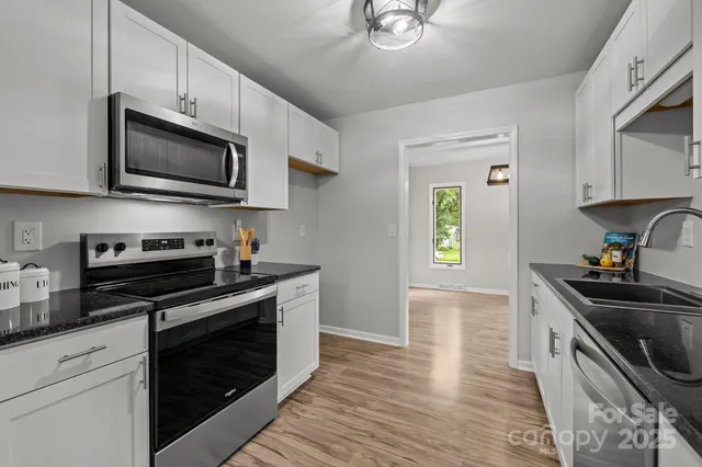 a kitchen with stainless steel appliances a stove microwave and sink