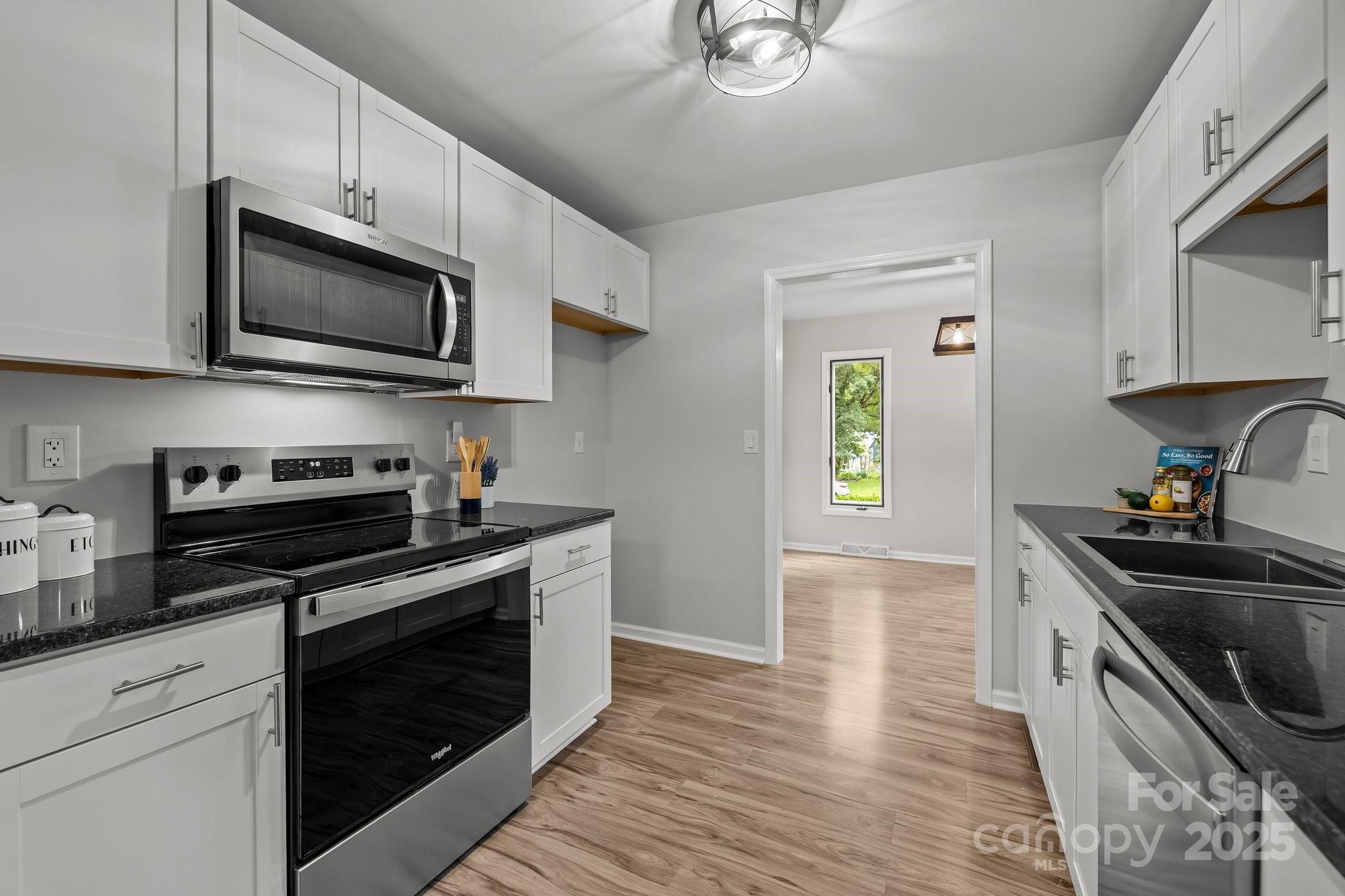 13446 Idlefield Lane Matthews, NC 28105 - Photo 4 of 42 a kitchen with stainless steel appliances a stove microwave and sink