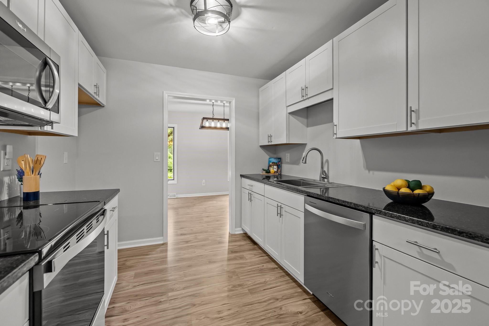 13446 Idlefield Lane Matthews, NC 28105 - Photo 5 of 42 a kitchen with granite countertop a sink dishwasher stove and cabinets