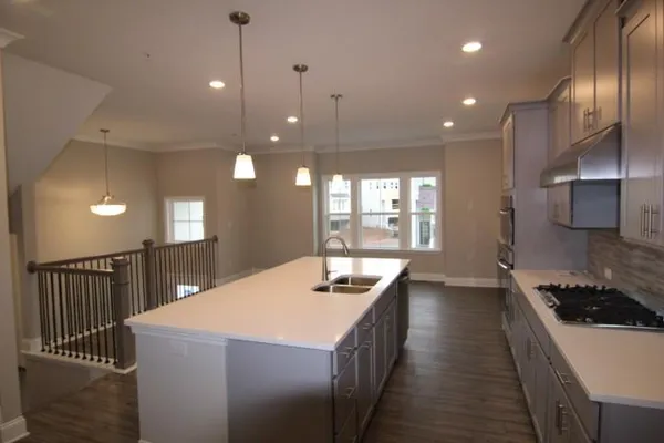 a kitchen with stainless steel appliances kitchen island granite countertop a sink and a refrigerator