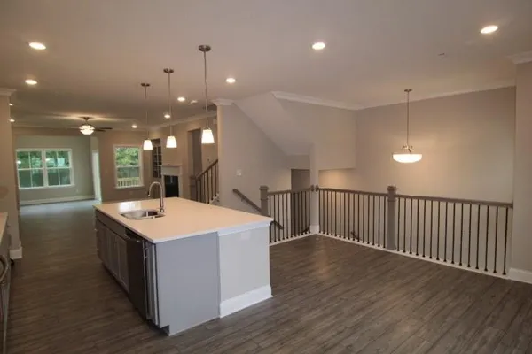 a large kitchen with kitchen island a sink wooden floor and a refrigerator
