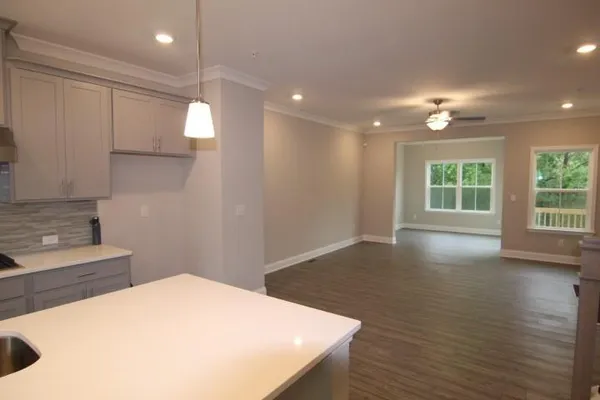 a kitchen with kitchen island a sink stainless steel appliances and wooden floor