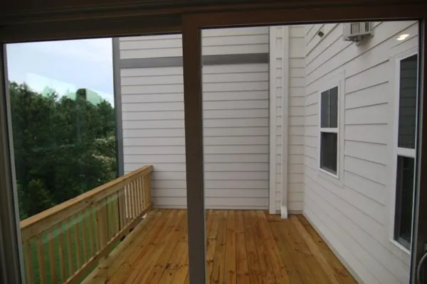 a view of a balcony with wooden floor and fence