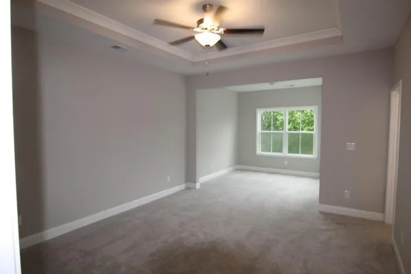 an empty room with a window and a fan