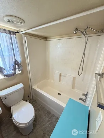 a bathroom with a toilet and a bathtub