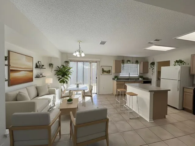 a living room with furniture and a dining table with kitchen view