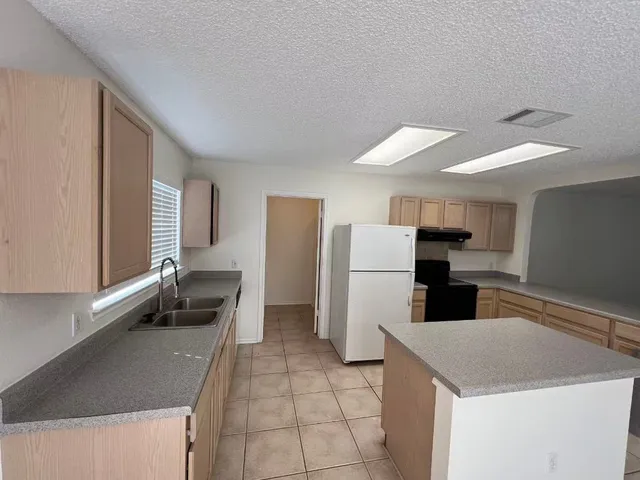 a kitchen with refrigerator and stove