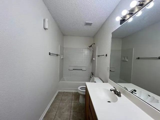 a bathroom with a tub sink and mirror