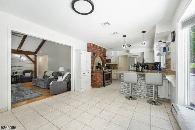 a kitchen with stainless steel appliances kitchen island granite countertop a refrigerator and microwave