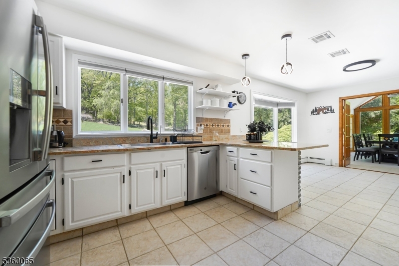 26 Danville Mountain Road Great Meadows, NJ 07838 - Photo 18 of 49 a large white kitchen with cabinets a sink a stove a dining table and chairs
