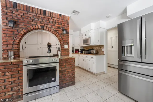 a kitchen with stainless steel appliances granite countertop a stove a refrigerator and a stove