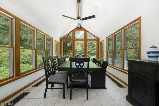 a dining room with furniture large windows and a chandelier