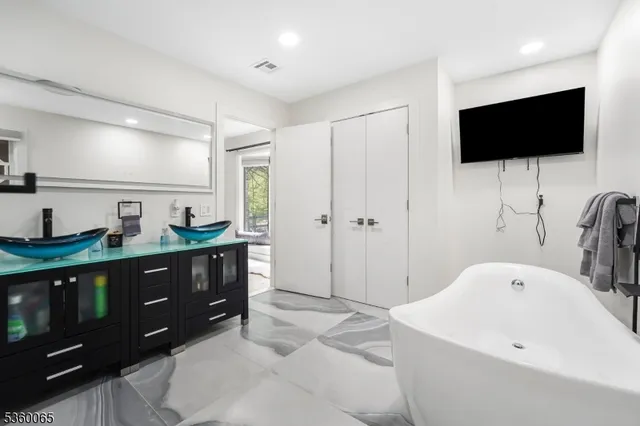 a spacious bathroom with a tub sink and mirror