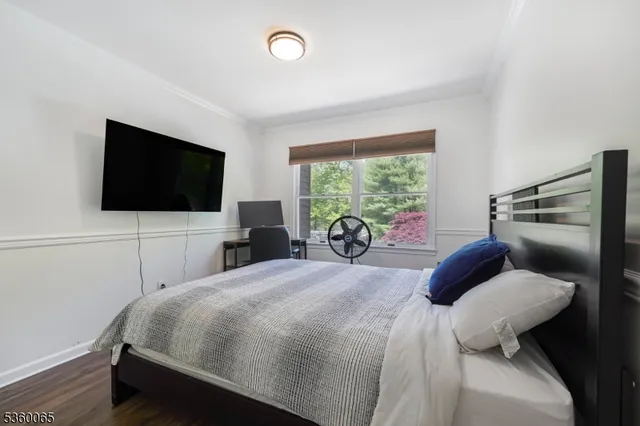 a bedroom with a bed and a flat tv screen on the dresser