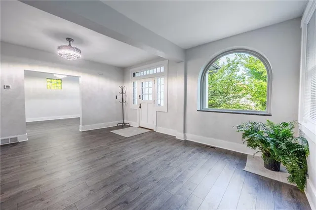 an empty room with wooden floor and window