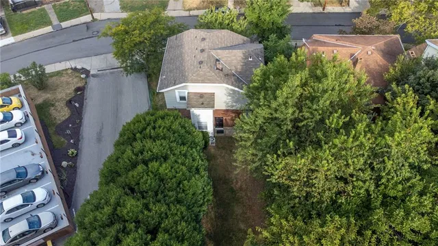 an aerial view of a house with outdoor space and trees all around