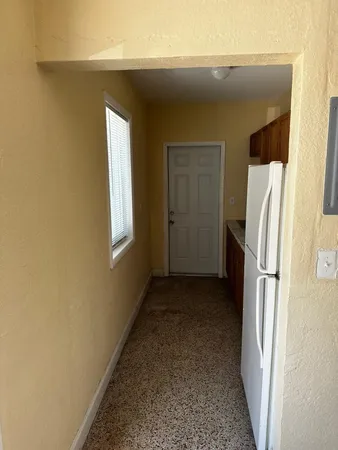 a view of a storage & utility room with refrigerator