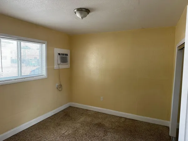 an empty room with closet and a ceiling fan