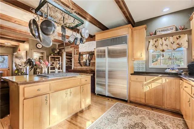 a kitchen with stainless steel appliances granite countertop a sink and a refrigerator