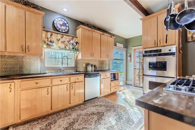 a kitchen with stainless steel appliances granite countertop a stove a sink and a refrigerator