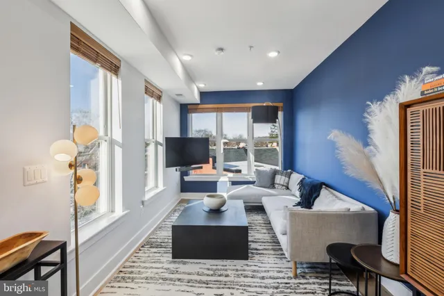 a living room with furniture fireplace and a large window